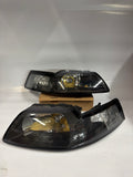 AS IS 99-04 FORD MUSTANG BLACK HOUSING AND CLEAR WITH CLEAR HEADLIGHTS