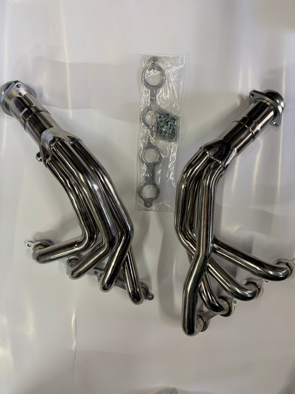 Set of polished metal exhaust pipes on a white background