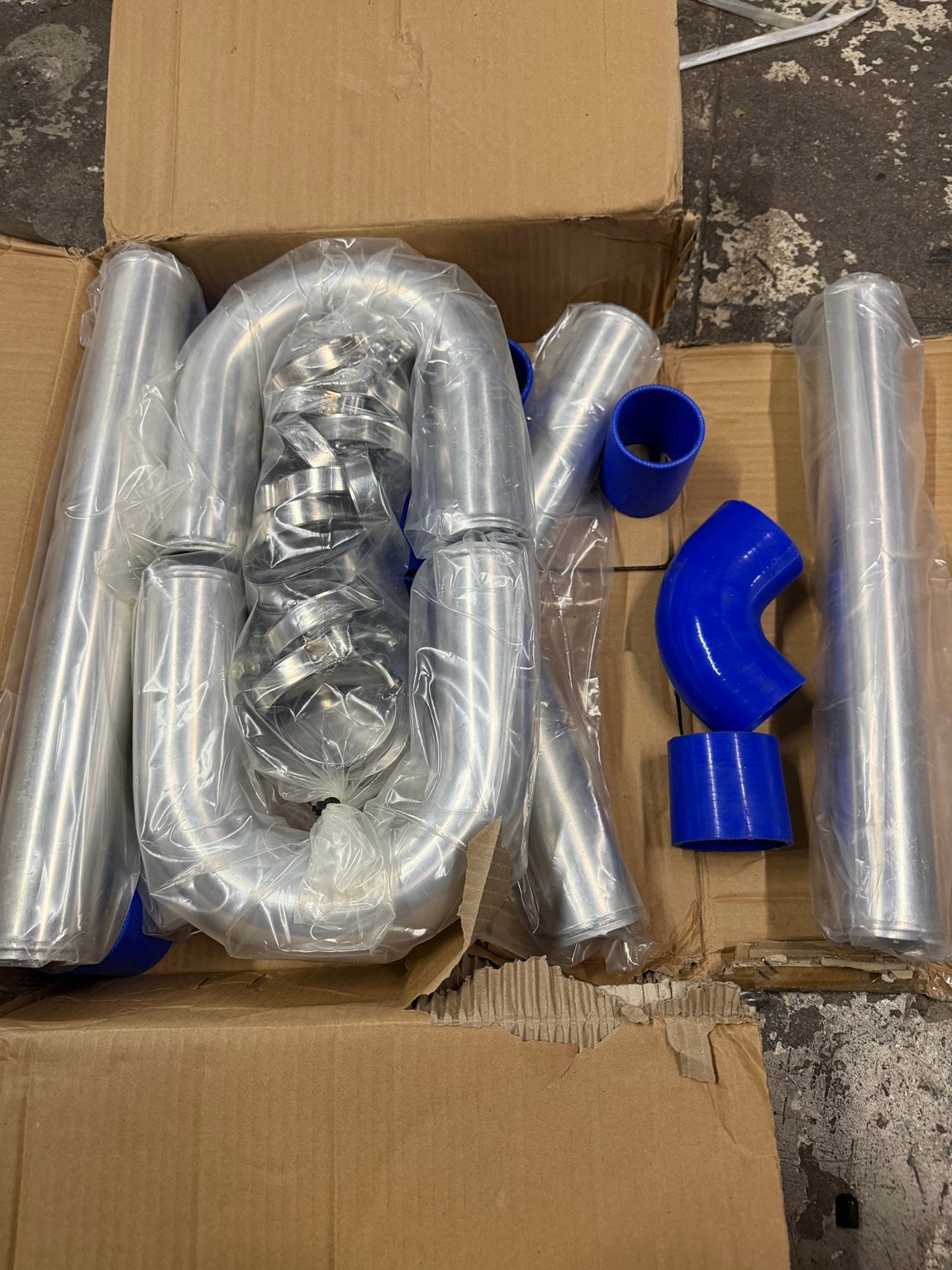 Actual DNA Motoring piping kit in box, silver aluminum pipes blue couplers and clamps