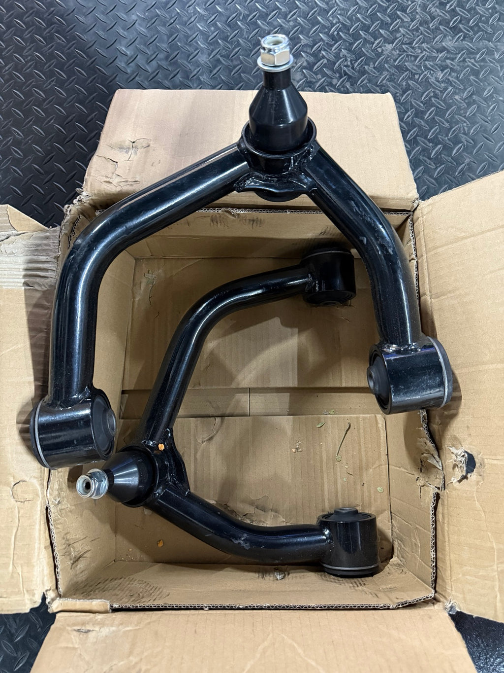 Actual open-box slightly used FUCA-ZTL-112 upper control arm pair, black with visible scuffs