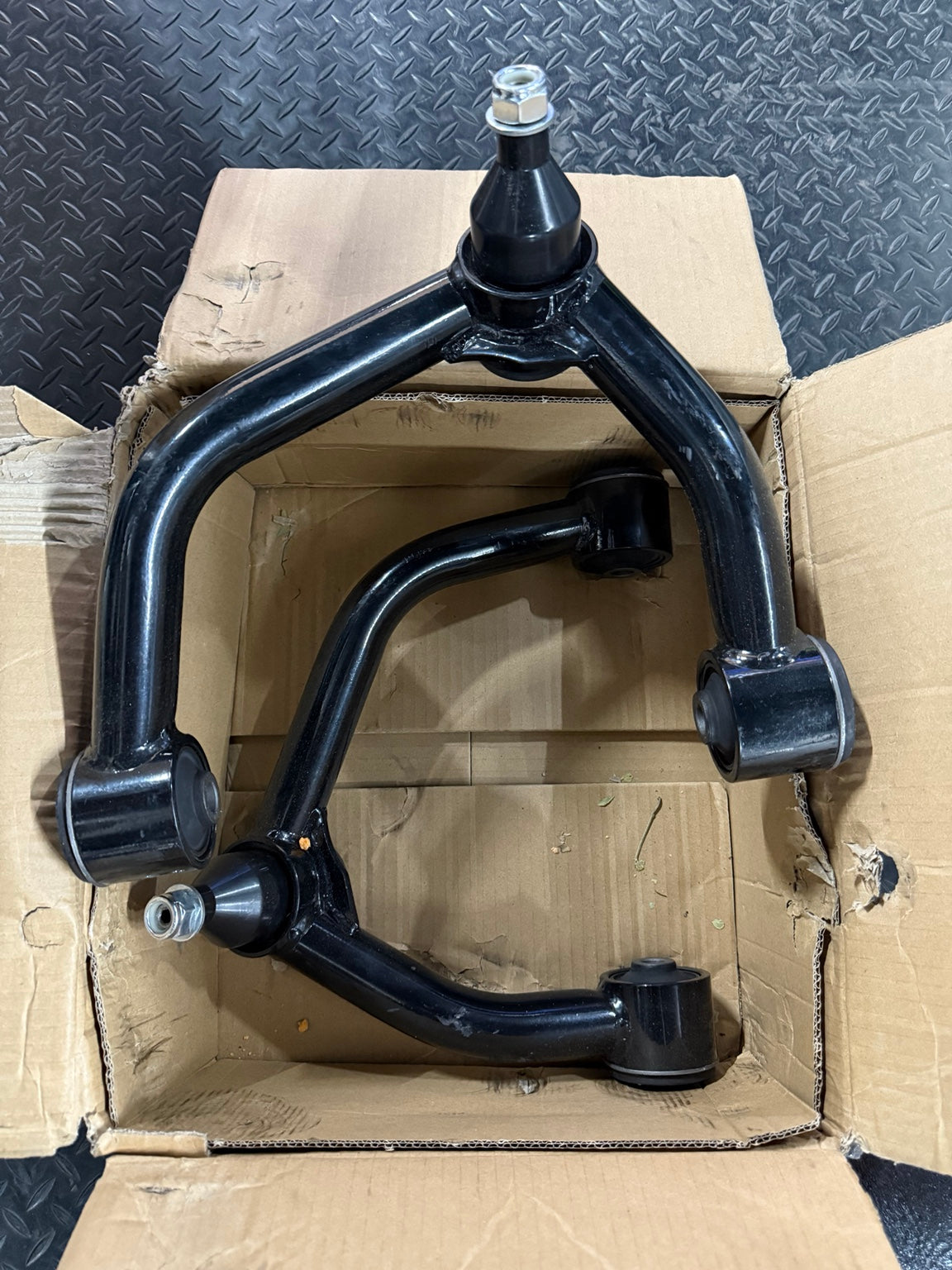 Actual open-box slightly used FUCA-ZTL-112 upper control arm pair, black with visible scuffs