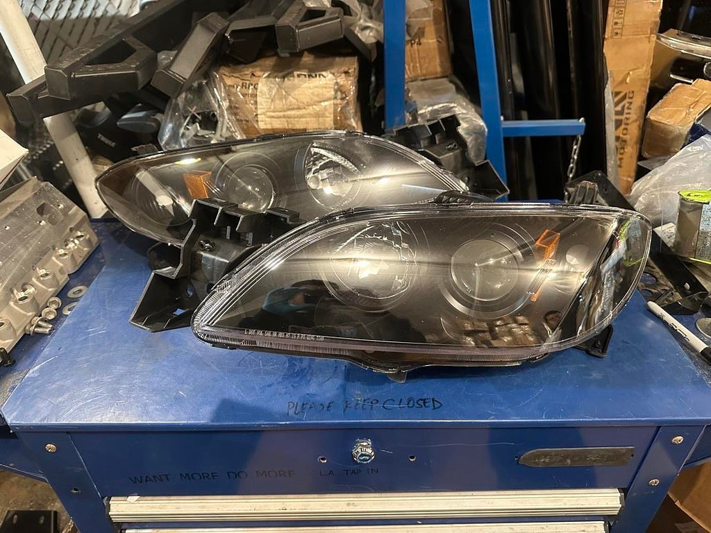 04-09 MAZDA 3 4DR BLACK HOUSING AND CLEAR PROJECTOR HEADLIGHTS