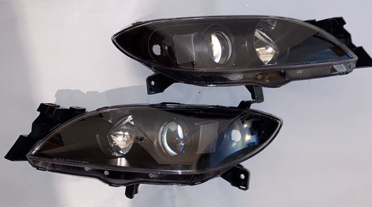 04-09 MAZDA 3 4DR BLACK HOUSING AND CLEAR PROJECTOR HEADLIGHTS