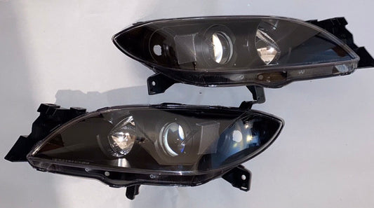 04-09 MAZDA 3 4DR BLACK HOUSING AND CLEAR PROJECTOR HEADLIGHTS