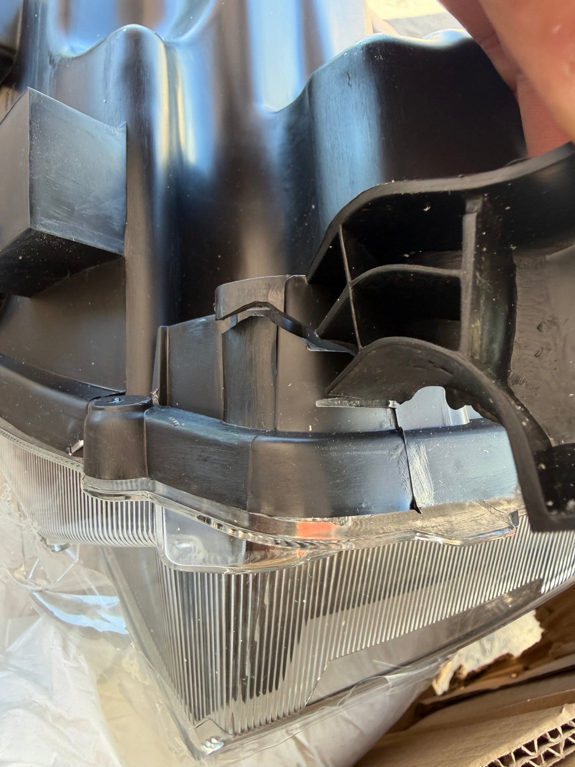 Left headlight cracked housing and mounting area detail